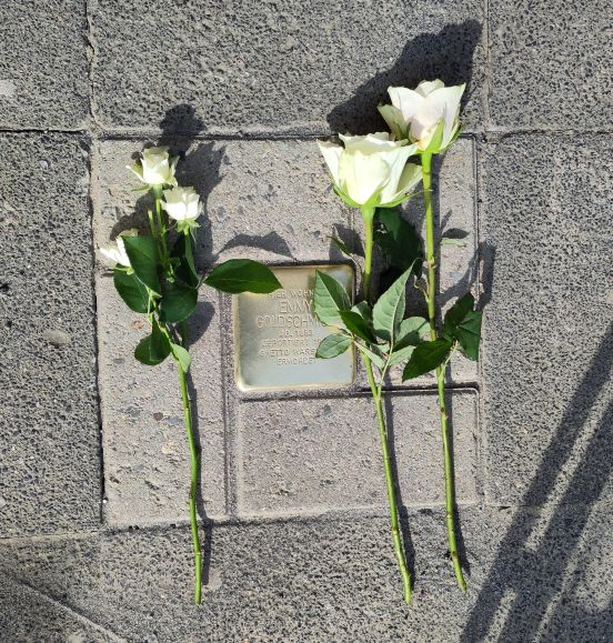 Auf dem frisch verlegten Stolperstein für Emmy Goldschmidt sind zum Gedenken weiße Rosen abgelegt.
