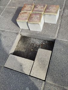 Vorbereitetes Loch für fünf Stolpersteine, die schon daneben bereitgelegt sind