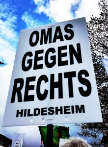 Demoplakat mit dem Text „Omas gegen rechts Hildesheim“, im Hintergrund ein Stück blauer Himmel