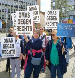 Omas halten Plakate mit dem Text „OMAS GEGEN RECHTS – Hildesheim“ in die Höhe.