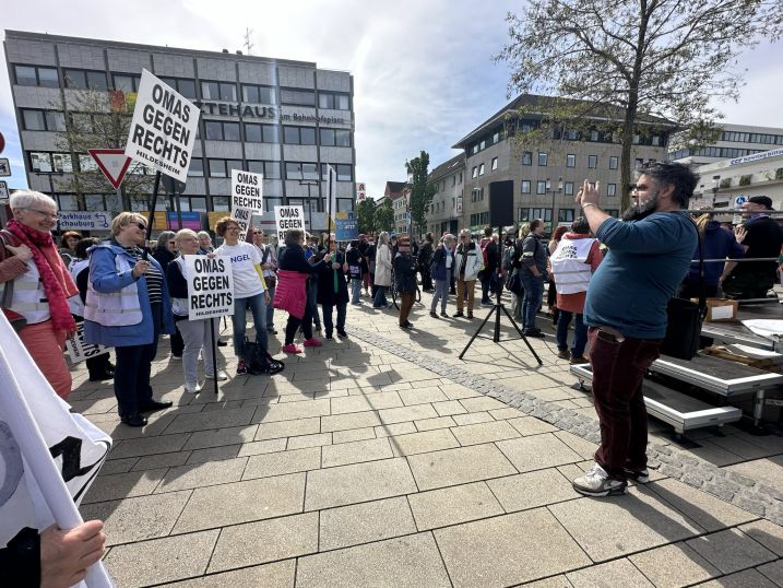 Ein Mann fotografiert die fröhliche Gruppe der OMAS GEGEN RECHTS auf dem Bahnhofsvorplatz in Hildesheim.