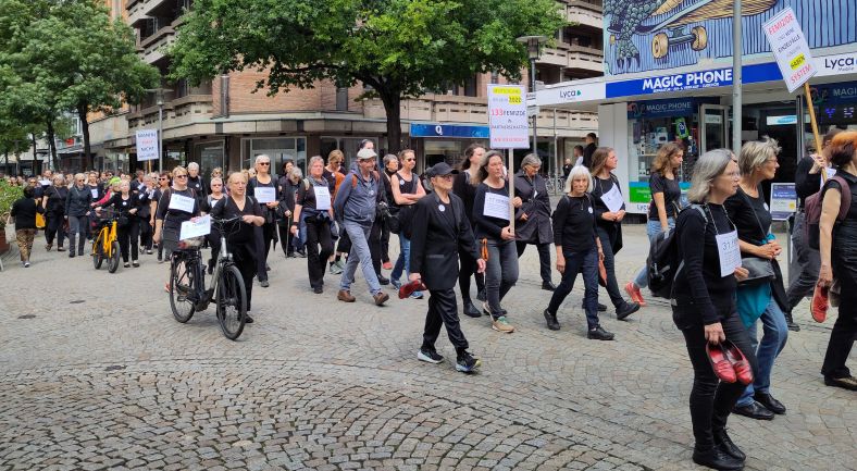 Schweigend ziehen Menschen in Schwarz durch Hildesheim, um auf Femizide = Frauentötungen aufmerksam zu machen.
