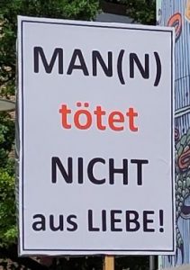 Ein Plakat auf dem Schweigemarsch gegen Femizide: „Man(n) tötet nicht aus Liebe!“