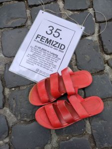 Ein rotes Paar Schuhe, darunter das Schild für den „35. Femizid“. Am 21.05.2024 hat ein Mann seine Ex-Partnerin getötet, weil sie sich von ihm getrennt hatte.