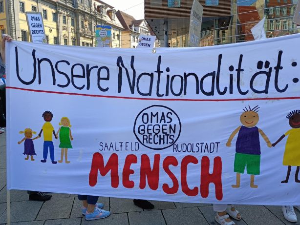 Foto eines Demo-Transparents mit der Aufschrift "Unsere Nationalität: Mensch"