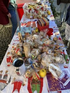 Auf weihnachtlich bedrucktem Stoff präsentieren wir unser Angebot: Kekse, Weihnachtskarten, Marmeladen – und Informationen.