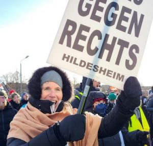 Eine warm eingemummelte Hildesheimer OMA GEGEN RECHTS steht bei der Kundgebung in Riesa mit ihrem Plakat strahlend in der Menge.