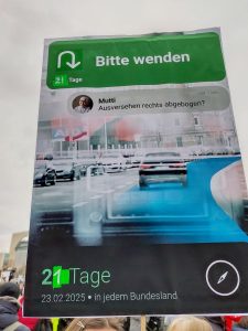 Demoplakat im Stil einer Navigations-App: "Bitte wenden." Dazu ein Pfeil, der zur Umkehr auffordert. 21 Tage Darunter eine Handy-Nachricht von: Mutti: "Aus Versehen rechts abgebogen?"