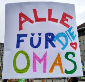 Demoplakat. In bunten Buchstaben steht darauf: "Alle für die OMAS"