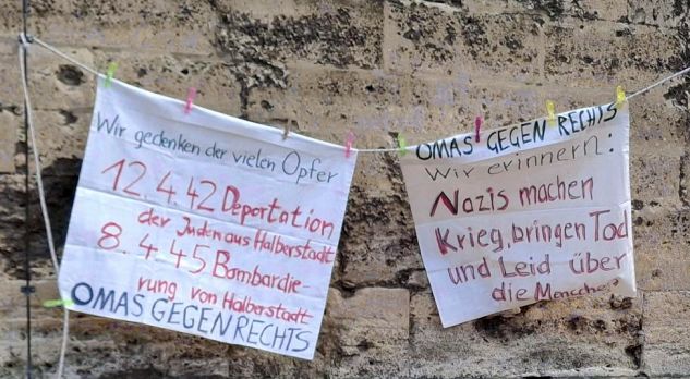 Bei der Mahnwache aufgehängte Transparente. Auf dem einen steht „Wir gedenken der vielen Opfer: 12.4.42 Deportation der Juden aus Halberstadt. 8.4.45 Bombardierung von Halberstadt. Omas gegen Rechts“. Auf dem anderen steht: „Omas gegen Rechts. Wir erinnern: Nazis machen Krieg, bringen Tod und Leid über die Menschen“