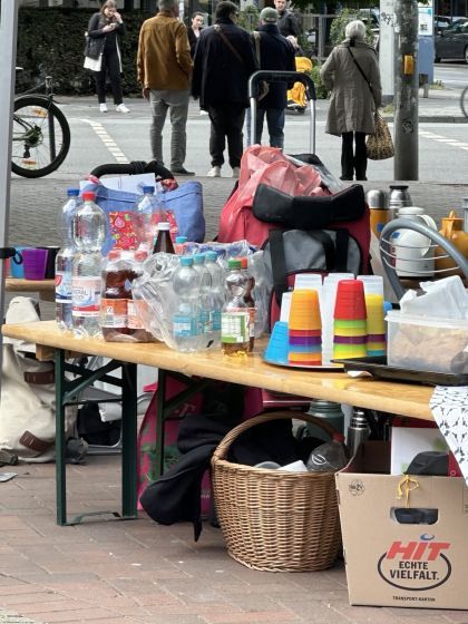 Auf einer Bierbank stehen Getränkeflaschen, Plastikbecher und noch allerhand weiterer Fest-Bedarf.