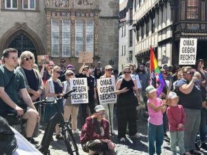 Menschen auf der Demo für das AfD-Verbot. Man sieht Schilder, unter anderem der OMAS GEGEN RECHTS und eine Regenbogenfahne.