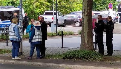 Zwei OMAS GEGEN RECHTS sprechen mit zwei AfD-Typen und werden dabei aufmerksam von vier Polizeikräften beäugt.