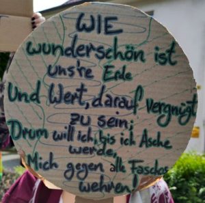 Demoschild: Wie wunderschön ist uns're Erde und wert, darauf vergnügt zu sein; drum will ich, bis ich Asche werde, mich gegen alle Faschos wehren!