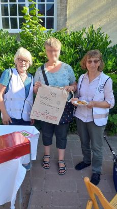 Zwei OMAS mit einer Elzerin. Letztere hält ein Schild in der Hand, auf dem steht: "Mit voller Überzeugung für Demokratie"