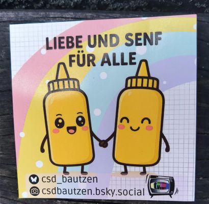 Ein Plakat mit zwei Senfflaschen, die sich fröhlich die Hände reichen. Aufschrift: "Liebe und Senf für alle"