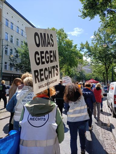 Foto des Demonstrationszugs. Im Nahbereich mehrere OMAS GEGEN RECHTS, eine davon hält das Schild der Hildesheimer OMAS.