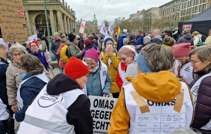 Auf dem Opernplatz in Hannover hat sich eine Menschenmenge versammelt. Im Vordergrund die Gruppe der OMAS GEGEN RECHTS aus Hildesheim.